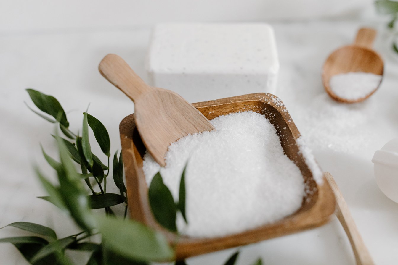 A Wooden Bowl with Rock Salt with Wooden Spoon